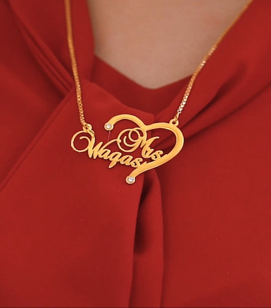 Gold necklace with a heart-shaped pendant on a red fabric background