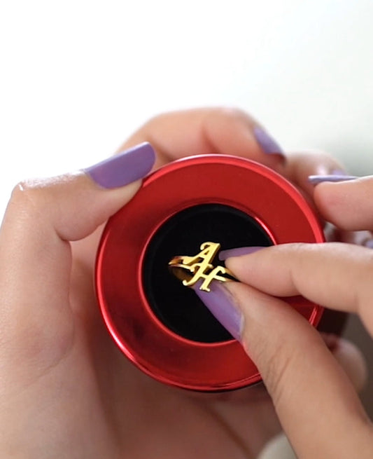 Red jewelry box with a gold clasp held by a hand, branded 'Customized Jewellers'.